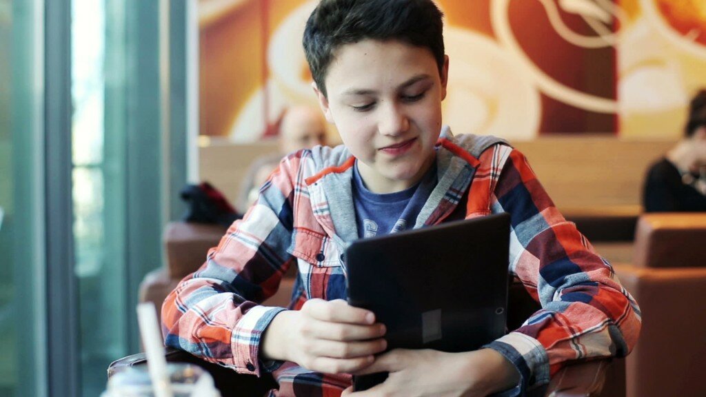 stock-footage-young-teenager-with-tablet-computer-sitting-in-cafe